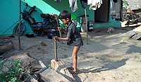 Little boy with a machete carves a coconut palm into a Cricket bat